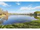 A calm community pond reflecting the sky and nearby homes, emphasizing the tranquil neighborhood setting at 8224 Simpson Falls Ct # 8224, Sarasota, FL 34243