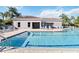 Large, bright swimming pool surrounded by lounge chairs and palm trees, with an adjacent building at 8224 Simpson Falls Ct # 8224, Sarasota, FL 34243