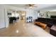 Open floor plan with a spacious living room featuring tile floors, a ceiling fan, and a glimpse into the kitchen at 8409 43Rd W Ave, Bradenton, FL 34209