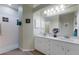Bright bathroom with dual sinks, white cabinetry, and a walk-in shower at 915 Sw Barclay Ct, Venice, FL 34293
