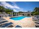 Relax by this community pool with sun loungers, shaded cabana, and views of the clubhouse at 915 Sw Barclay Ct, Venice, FL 34293