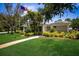 Beautiful single-story home with a manicured lawn, a sidewalk, and an American flag flying high at 915 Sw Barclay Ct, Venice, FL 34293