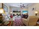 Comfortable living room with plush seating, a ceiling fan, and sliding glass doors leading to an outdoor patio area at 915 Sw Barclay Ct, Venice, FL 34293