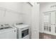 This laundry room features a modern washer and dryer, and ample overhead shelving for storage at 11194 Spring Point Cir, Riverview, FL 33579