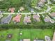 Aerial image of neighborhood with tile roofs, screened pools, and lush green lawns at 1015 143Rd Ne St, Bradenton, FL 34212