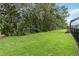 Large backyard featuring mature trees and black fencing to enhance privacy and beauty at 1015 143Rd Ne St, Bradenton, FL 34212