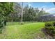 Manicured backyard with lush lawn, secure fence, and view of a screened-in enclosure at 1015 143Rd Ne St, Bradenton, FL 34212