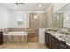 Upscale bathroom with walk-in shower, separate soaking tub, and double vanity with granite countertop at 1015 143Rd Ne St, Bradenton, FL 34212