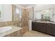 Luxurious bathroom with walk-in shower, separate soaking tub, and double vanity with granite countertop at 1015 143Rd Ne St, Bradenton, FL 34212
