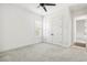Bright bedroom with neutral carpet, a ceiling fan, and double doors, offering a calm and inviting space at 1015 143Rd Ne St, Bradenton, FL 34212