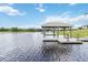 Scenic view of boat dock with a covered lift on a calm lake, perfect for boating enthusiasts at 1015 143Rd Ne St, Bradenton, FL 34212