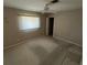 A carpeted bedroom with a window, fan, and door at 1036 Arden Nw Ter, Port Charlotte, FL 33948