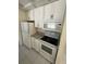 Kitchen with white appliances including a refrigerator, microwave, and oven, complemented by white cabinets at 1036 Arden Nw Ter, Port Charlotte, FL 33948