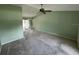 Spacious carpeted living room with fan and sliding door at 1036 Arden Nw Ter, Port Charlotte, FL 33948