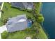 An aerial view of a home with a screened pool area, lush backyard and waterfront views at 12015 Forest Park Cir, Bradenton, FL 34211