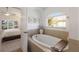 This is a primary bathroom suite featuring a soaking tub, neutral decor, and natural light at 12015 Forest Park Cir, Bradenton, FL 34211