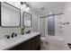 Stylish bathroom featuring a double vanity, framed mirrors, and a shower-tub with a decorative tile accent wall at 12015 Forest Park Cir, Bradenton, FL 34211