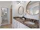 This is a bathroom with double sinks with granite countertops, modern lighting, and neutral decor at 12015 Forest Park Cir, Bradenton, FL 34211