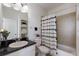 Cozy bathroom featuring a marble countertop vanity, shelving, and a shower-tub with a patterned curtain at 12015 Forest Park Cir, Bradenton, FL 34211