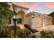 Charming home featuring an arched entryway and a well-manicured front yard with tropical landscaping at 12015 Forest Park Cir, Bradenton, FL 34211