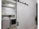 This is a laundry room with a sliding barn door, white cabinets, and modern washer and dryer at 12015 Forest Park Cir, Bradenton, FL 34211