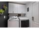 This is a laundry room featuring a modern washer and dryer, white cabinets, and modern decor at 12015 Forest Park Cir, Bradenton, FL 34211