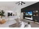 Spacious living room with TV, modern ceiling fan, white couch and view to the kitchen at 12015 Forest Park Cir, Bradenton, FL 34211
