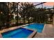 Screened-in pool and jacuzzi with a view of the backyard and lake at 12015 Forest Park Cir, Bradenton, FL 34211