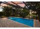 Backyard screened-in pool and jacuzzi overlooking the backyard with a lake view at 12015 Forest Park Cir, Bradenton, FL 34211