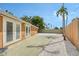 Spacious backyard featuring a concrete patio and white rock landscaping with tropical palm trees at 1203 Lyric Ln, Sarasota, FL 34242