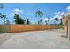 Large concrete patio with a wood fence and beautiful tropical foliage, perfect for outdoor enjoyment at 1203 Lyric Ln, Sarasota, FL 34242