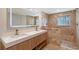 Bathroom with double sinks, marble countertop, a large, light-up mirror and tile shower at 1203 Lyric Ln, Sarasota, FL 34242