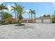 Charming home with a two-car garage and lush landscaping, surrounded by mature palm trees at 1203 Lyric Ln, Sarasota, FL 34242