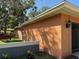 Exterior of the home with orange paint, lush lawn and plants at 13017 Club Dr, Hudson, FL 34667