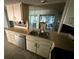 Features a double sink, dishwasher, and cabinetry with a view to the outside enclosed porch with hanging chandelier at 13017 Club Dr, Hudson, FL 34667