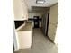 View of the kitchen with black backsplash, stainless steel refrigerator and tile flooring at 13017 Club Dr, Hudson, FL 34667