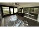 Enclosed sunroom with multiple glass doors and tile flooring, awaiting renovation at 13017 Club Dr, Hudson, FL 34667