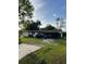 Cozy single-story home features a large front yard and a car parked in the driveway at 14396 Pambar Ave, Port Charlotte, FL 33953