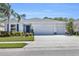 Charming one-story home with a three-car garage, well-manicured lawn, and lush landscaping at 15508 High Bell Pl, Bradenton, FL 34212