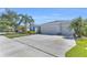 Attractive home exterior showcasing a three-car garage, well-maintained lawn, and lush palm trees at 15508 High Bell Pl, Bradenton, FL 34212