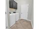 Laundry room features a washer and dryer, upper cabinets, and tile flooring at 15508 High Bell Pl, Bradenton, FL 34212