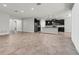 Open-concept living room and kitchen features tile flooring and modern black appliances at 15508 High Bell Pl, Bradenton, FL 34212