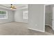 Bright main bedroom featuring gray carpet, fan, and natural light at 15508 High Bell Pl, Bradenton, FL 34212
