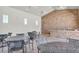 Inviting outdoor seating area with tables, chairs, and a charming stone wall, perfect for relaxing and socializing at 15508 High Bell Pl, Bradenton, FL 34212