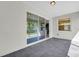 A covered patio with grey tile floors, sliding glass doors and a window provides an inviting outdoor space at 15508 High Bell Pl, Bradenton, FL 34212