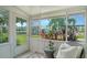 Relaxing lanai with wicker chair, side table, and serene view of lush landscaping at 1838 Restful Dr # K-1, Bradenton, FL 34207