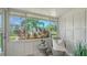 Cozy lanai with wicker chair, side table, and serene view of the complex grounds at 1838 Restful Dr # K-1, Bradenton, FL 34207