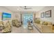 Bright living room with stylish furniture, beach-themed decor, and access to the lanai at 1838 Restful Dr # K-1, Bradenton, FL 34207