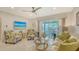 Bright living room with stylish furniture, beach-themed decor, and access to the lanai at 1838 Restful Dr # K-1, Bradenton, FL 34207
