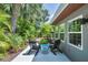 Relaxing backyard patio with tropical landscaping, outdoor chairs, and a small table at 1919 Laurel St, Sarasota, FL 34236